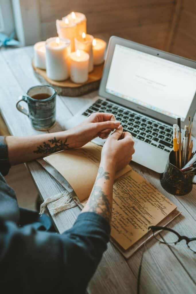 sitting by a laptop with some coffee and candles